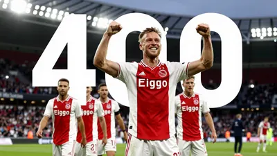 A photo of Davy Klaassen celebrating his 400th Ajax appearance with his teammates, with a big smile on his face and a...
