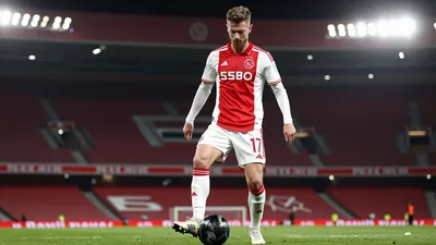 A photorealistic image of an anonymous AFC Ajax player in a red jersey with white sleeves, wearing a white pair of...