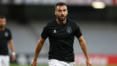 A photorealistic image of an anonymous Ajax defender, aged 25-30, with a rugged build, wearing a sleek black jersey with...