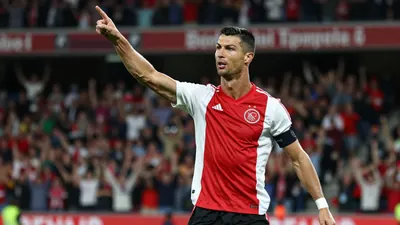 A photorealistic image of an anonymous Ajax player, aged 25-30, with a strong build, wearing a red jersey with white...