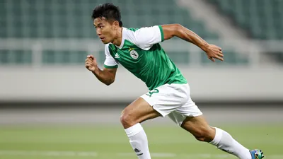 A photorealistic image of an anonymous Ajax player, aged 25-30, wearing a green and white jersey with a white collar, a...