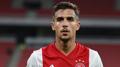 Mid-30s Ajax midfielder, athletic build, intense gaze, head-and-shoulders shot, dark red shirt with white sleeves, plain...