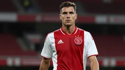 Mid-30s Ajax midfielder, athletic build, waist-up, intense gaze, dark red home shirt with white sleeves, plain cotton...